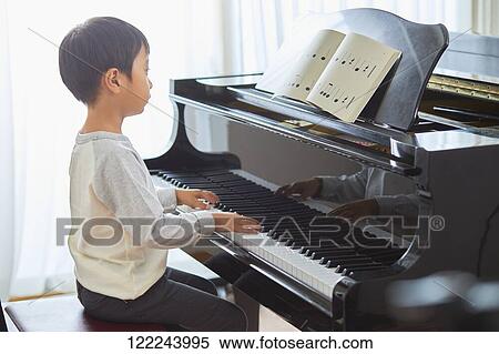 Stock Photography - Japanese kid practicing piano. Fotosearch