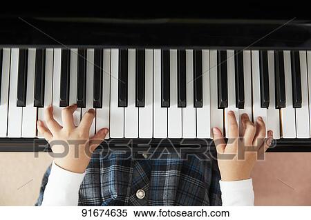 Stock Photography - Japanese kid practicing piano. Fotosearch