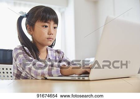 Picture - Japanese kid practicing programming. Fotosearch