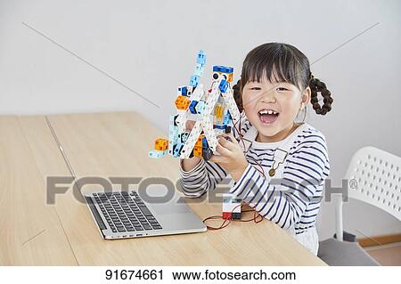 Stock Image - Japanese kid practicing programming. Fotosearch
