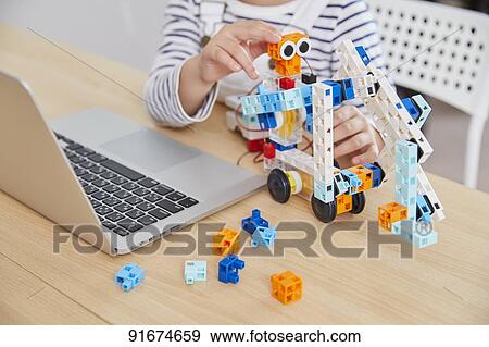 Stock Photo - Japanese kid practicing programming. Fotosearch