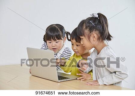 Stock Image - Japanese kids practicing programming. Fotosearch