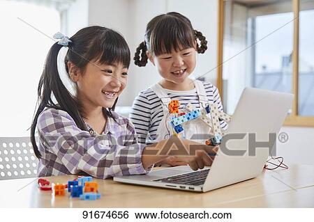 Stock Photograph - Japanese kids practicing programming. Fotosearch