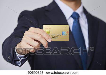 Stock Image - Japanese man holding credit card. Fotosearch