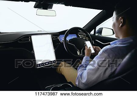 Stock Photo - Japanese man in self driving car. Fotosearch