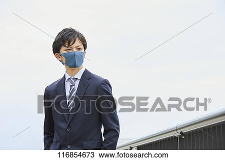Stock Image - Japanese man wearing mask. Fotosearch