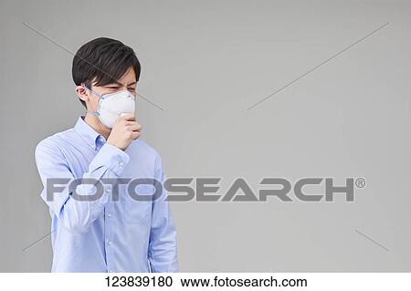 Stock Image - Japanese man wearing mask. Fotosearch