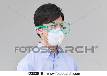 Stock Image - Japanese man wearing mask. Fotosearch