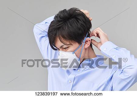 Stock Photo - Japanese man wearing mask. Fotosearch