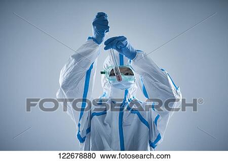 Stock Image - Japanese man wearing protective suit for disease prevention. Fotosearch