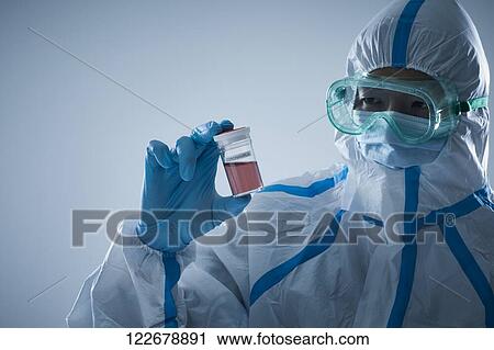 Stock Image - Japanese man wearing protective suit for disease prevention. Fotosearch
