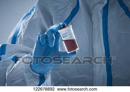 Stock Image - Japanese man wearing protective suit for disease prevention. Fotosearch