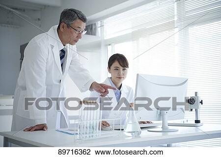 Stock Image - Japanese researchers in the lab. Fotosearch