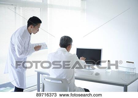 Stock Image - Japanese researchers in the lab. Fotosearch