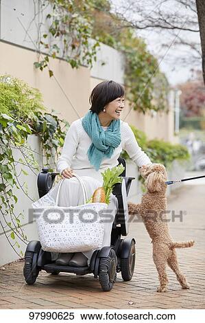 Stock Photography - Japanese senior woman on electric wheelchair. Fotosearch