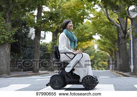 Stock Photography - Japanese senior woman on electric wheelchair. Fotosearch