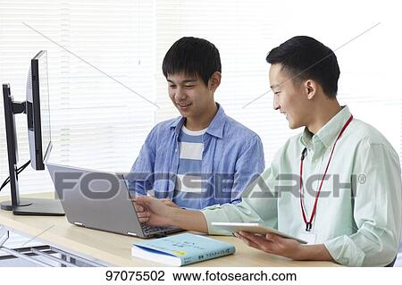Stock Image - Japanese teenager studying programming. Fotosearch