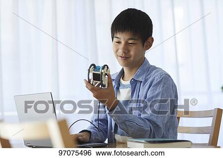 Stock Photograph - Japanese teenager studying programming. Fotosearch