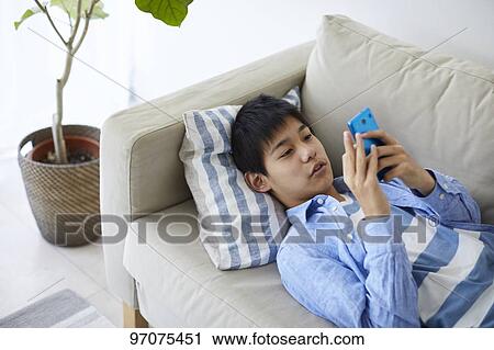 Stock Image - Japanese teenager with smartphone. Fotosearch