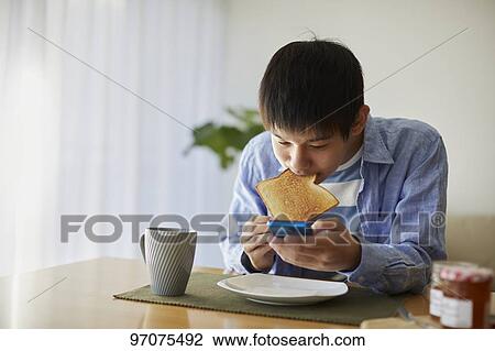 Stock Image - Japanese teenager with smartphone. Fotosearch
