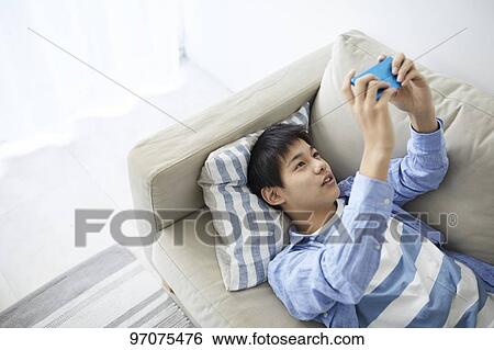 Stock Photograph - Japanese teenager with smartphone. Fotosearch
