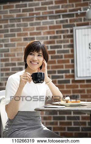 Stock Photo - Japanese woman at a cafe. Fotosearch