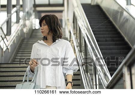 Stock Image - Japanese woman downtown. Fotosearch