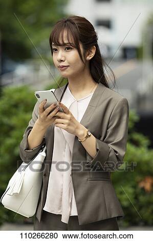 Stock Image - Japanese woman downtown. Fotosearch