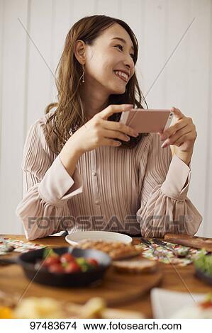 Picture - Japanese woman having home party. Fotosearch