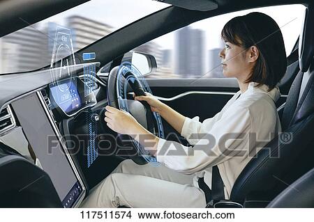 Picture - Japanese woman in self driving car. Fotosearch