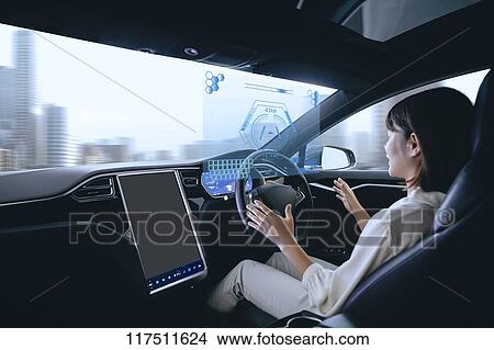 Picture - Japanese woman in self driving car. Fotosearch