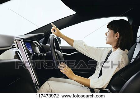 Stock Image - Japanese woman in self driving car. Fotosearch