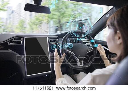 Stock Image - Japanese woman in self driving car. Fotosearch