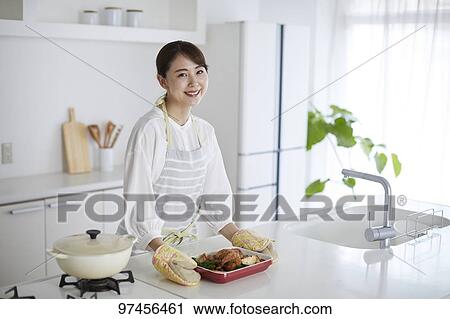 Stock Image - Japanese woman in the kitchen. Fotosearch