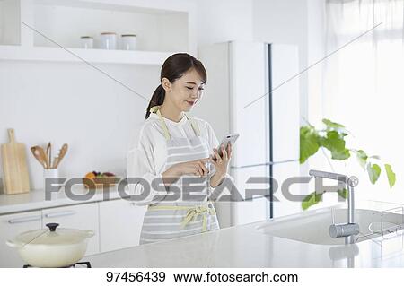Japanese woman in the kitchen View Large Photo Image Stock Photo - Japanese woman in the kitchen. Fotosearch