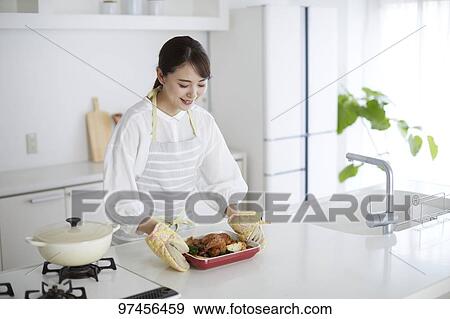 Stock Photo - Japanese woman in the kitchen. Fotosearch