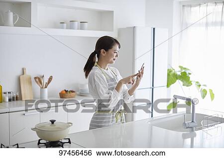 Stock Photograph - Japanese woman in the kitchen. Fotosearch