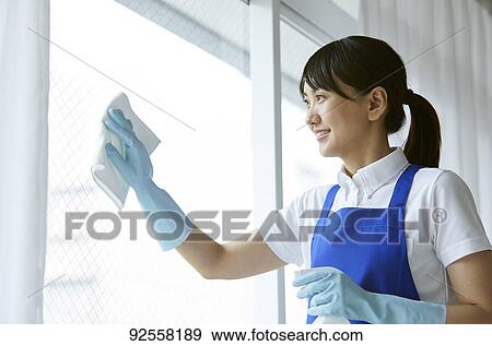 Stock Photo - Japanese woman wearing apron at home. Fotosearch
