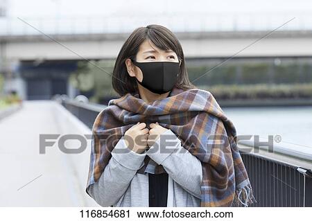 Stock Image - Japanese woman wearing mask. Fotosearch