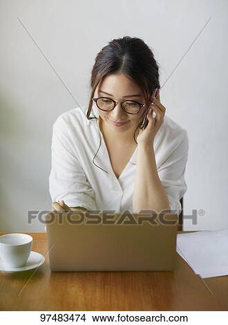 Picture - Japanese woman working at a cafe. Fotosearch