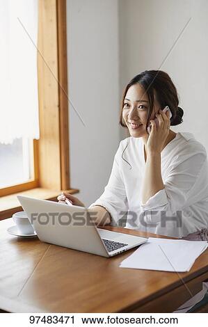 Japanese woman working at a cafe View Large Photo Image Stock Image - Japanese woman working at a cafe. Fotosearch