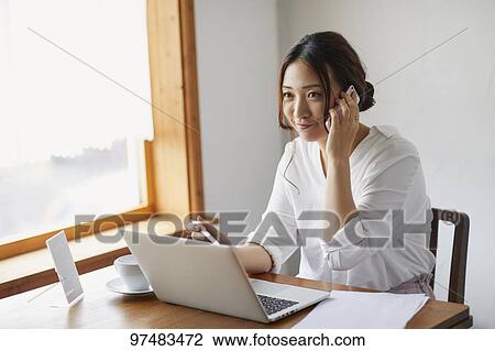 Japanese woman working at a cafe View Large Photo Image Stock Image - Japanese woman working at a cafe. Fotosearch