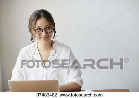 Stock Image - Japanese woman working at a cafe. Fotosearch