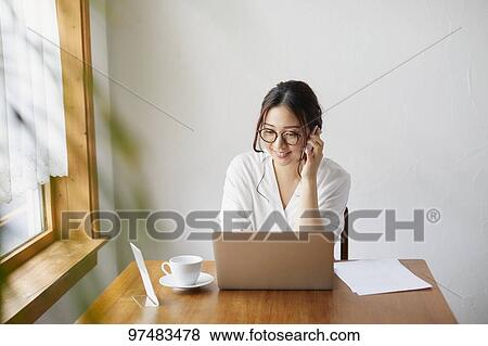 Japanese woman working at a cafe View Large Photo Image Stock Photo - Japanese woman working at a cafe. Fotosearch