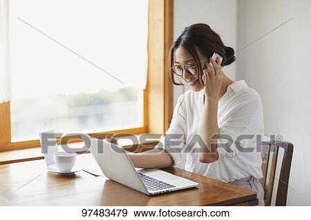Japanese woman working at a cafe View Large Photo Image Stock Photo - Japanese woman working at a cafe. Fotosearch