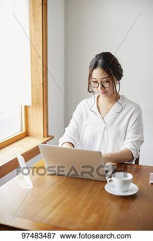 Japanese woman working at a cafe View Large Photo Image Stock Photo - Japanese woman working at a cafe. Fotosearch