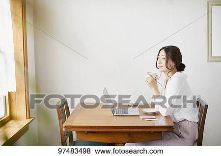 Stock Photo - Japanese woman working at a cafe. Fotosearch
