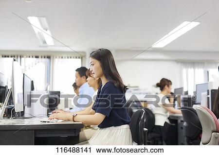 Stock Image - Japanese woman working in the office. Fotosearch