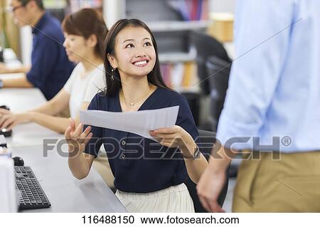 Stock Image - Japanese woman working in the office. Fotosearch