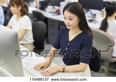 Stock Photo - Japanese woman working in the office. Fotosearch